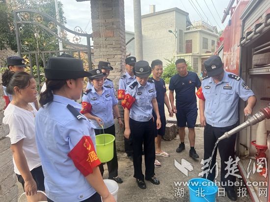 民輔警跟隨消防水車作業(yè)，通過(guò)肩挑手提的方式將清水送入行動(dòng)不便的老年、殘障村民的家中（通訊員 李麗君 攝） (3).jpg.jpg